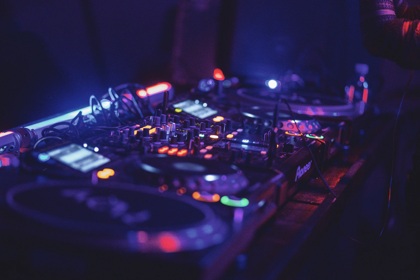 DJ mixing equipment under blue nightclub lighting